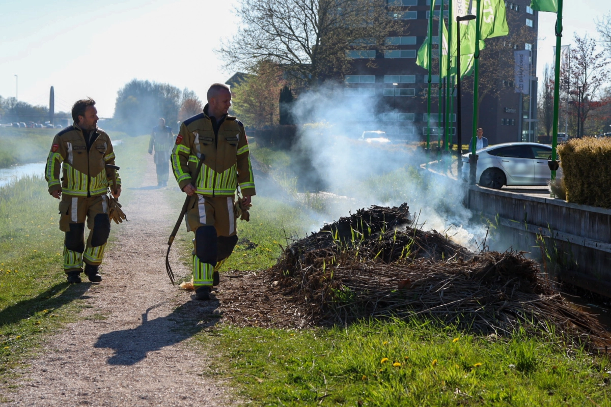Brand in bult hekkelafval langs schelpenpad